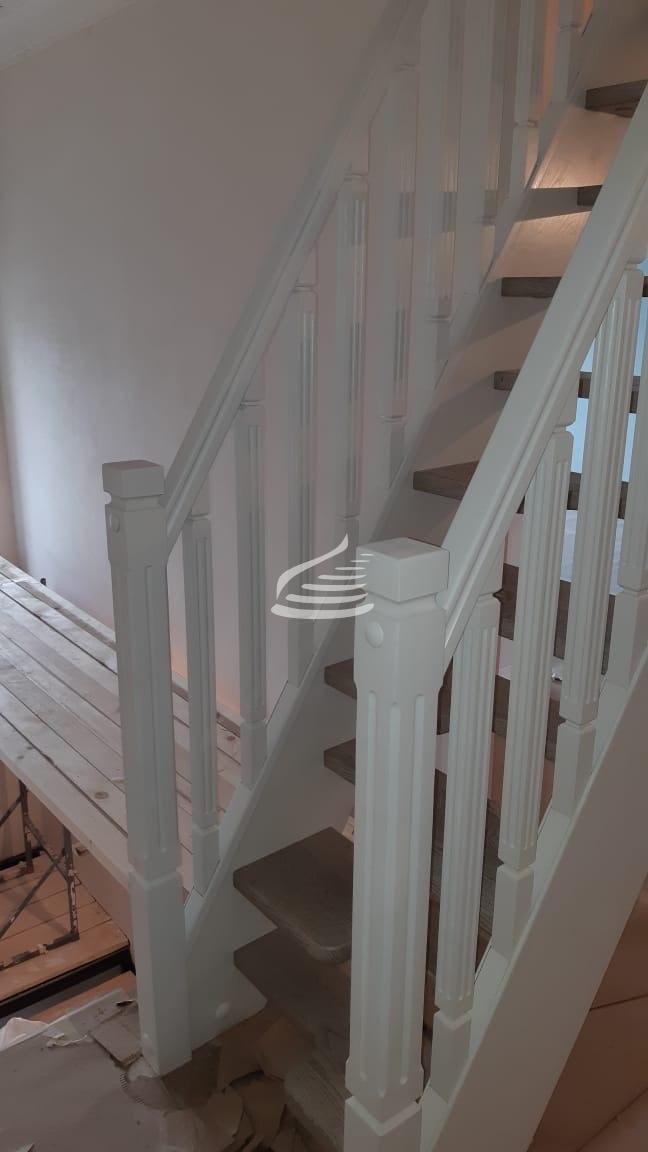 Лестница "Гусиный шаг" в тетивах, выполненная полностью из массива дуба. Ограждение выполнено в современном классическом стиле. Поручни изготовлены с 2D-элементами.