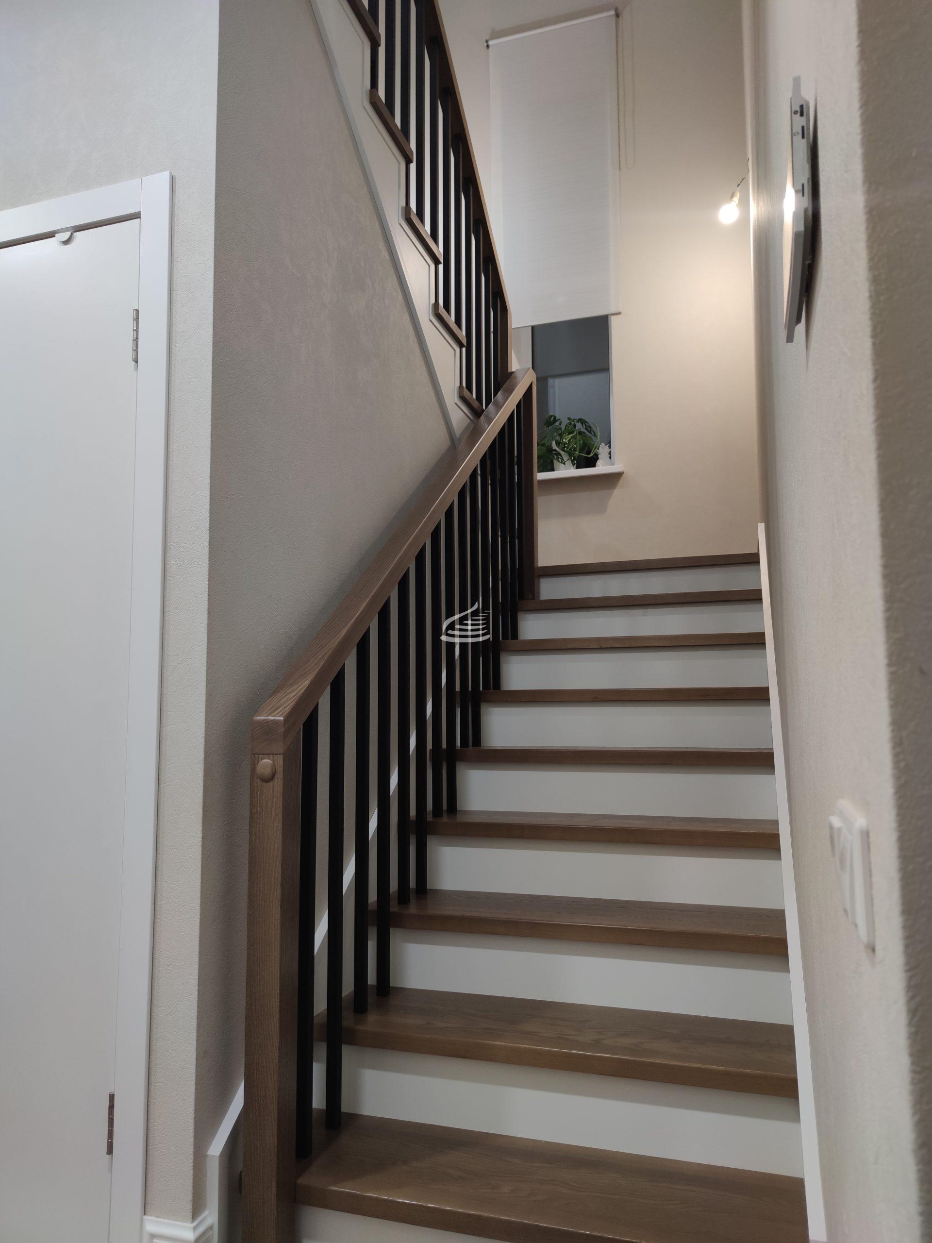 Строгость и сдержанность балясин, окрашенных в тон "черный муар", подчеркнута белоснежной фальш-тетивой, которая придает форму, создает контраст и вносит необходимый штрих к простой и сдержанной красоте этой лестницы.