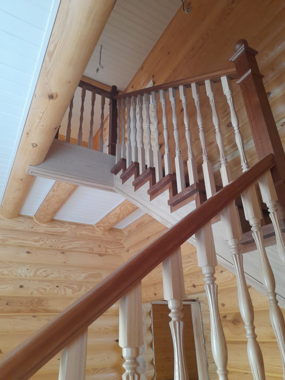 Классическая лестница из массива Ясеня в интерьере бревенчатого дома